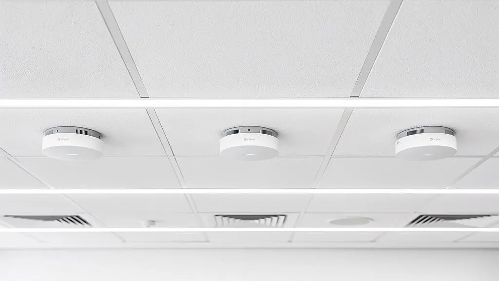 Plusieurs bornes WiFi professionnelles installées stratégiquement au plafond d'un bureau moderne